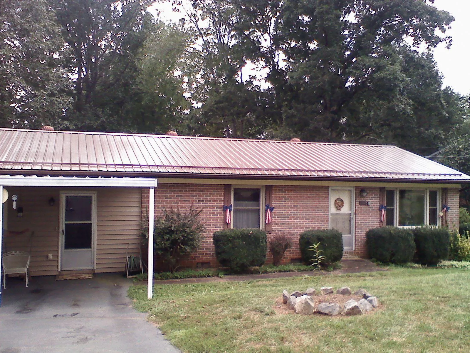 Bronze metal roof and carport on a brick ranch home — Roof Repair work by our crew in Gambier